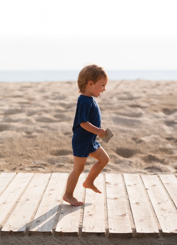 Child running on the beach boardwalk